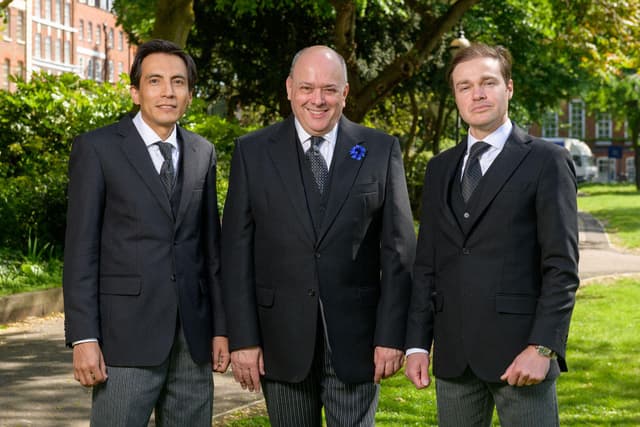 Three funeral directors from JH Kenyon in Fulham stand together in a local park